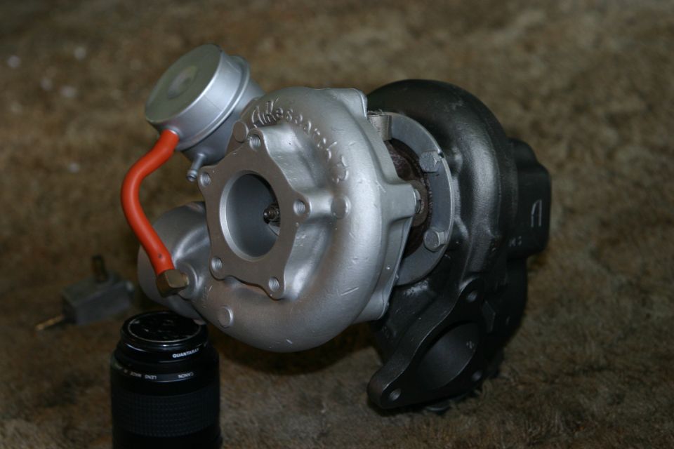 Turbocharger assembly with silver compressor housing and black turbine housing.