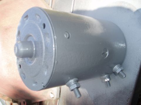 1980 Ford Bronco - A close-up view of a gray painted automotive generator or alternator with two threaded posts visible on the side. The front of the unit fea…