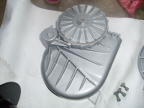 1980 Ford Bronco - A silver painted automotive part, possibly a transmission or differential housing, is shown on a white surface. Several bolts are visible i…