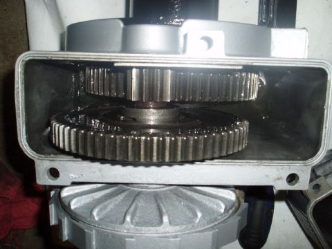1980 Ford Bronco - A close-up view of the internal gears of a vehicle's transmission or gearbox, showing two large metal gears covered in lubricant.