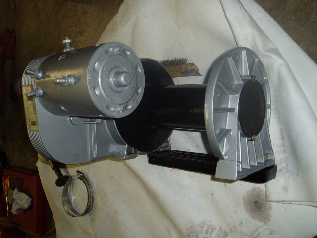 Silver and black electric winch with a cylindrical motor and drum.