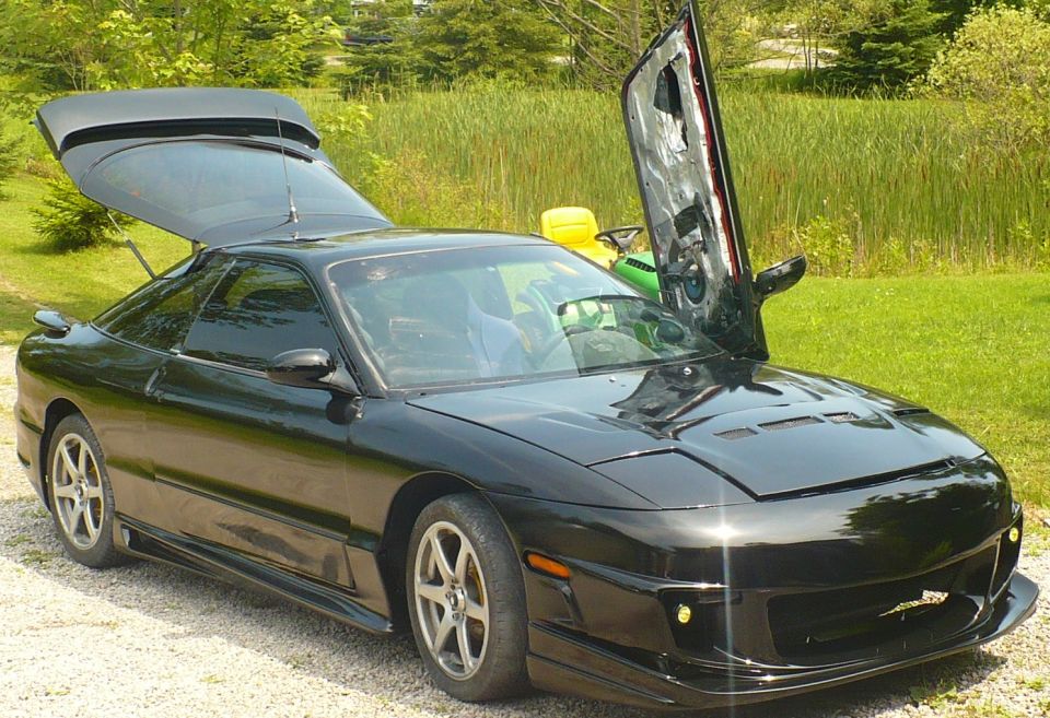 Black 1993 Ford Probe with doors and trunk open.