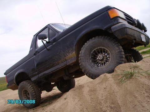 1990 Ford Bronco - This SUV is navigating a steep, sandy incline.