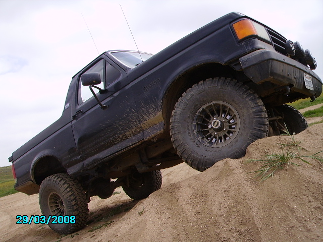 Dark blue SUV climbing a dirt hill at an angle