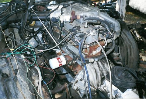1983 Ford Bronco - Close-up view of a vehicle's engine compartment, showing complex wiring and mechanical components.