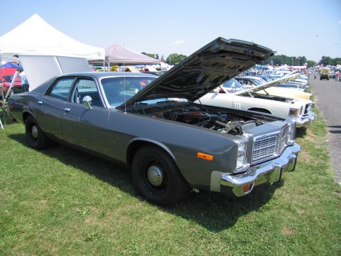 2001 Ford Crown Victoria - A gray sedan is parked on a grassy field with its hood open, revealing the engine compartment.