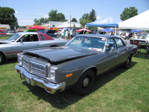 2001 Ford Crown Victoria - A gray sedan sits on a grassy field under a clear sky, with tents visible in the distance.