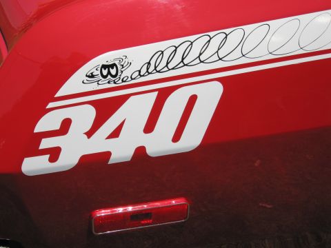 2001 Ford Crown Victoria - A red vehicle displays a white stripe with a cartoon eye and the number 340.