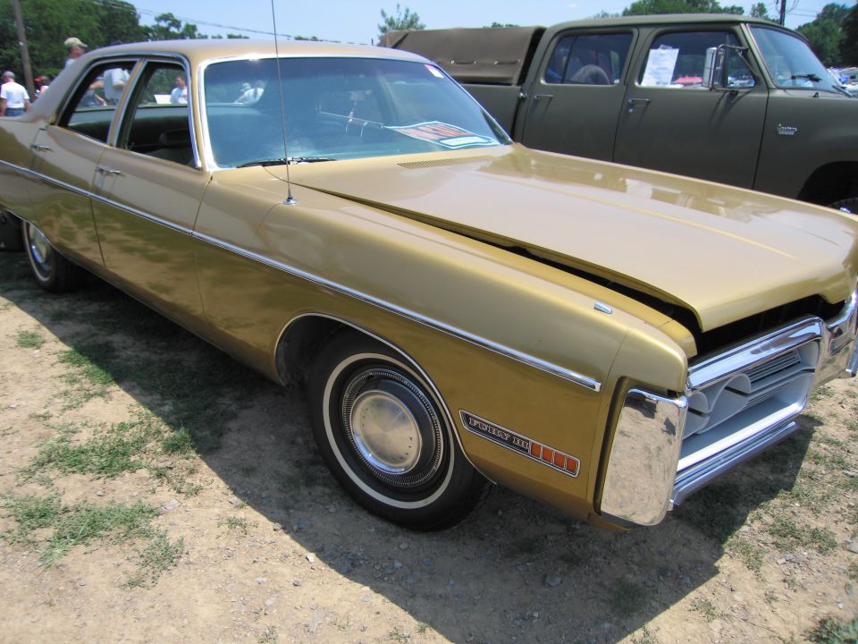 Gold Plymouth Fury sedan front three-quarter view at a car show
