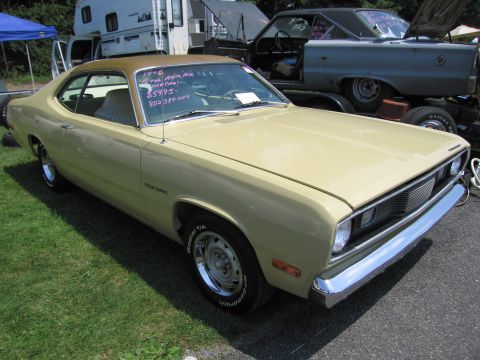 2001 Ford Crown Victoria - Photograph of a tan Plymouth Duster coupe at an outdoor car show, not a technical document.