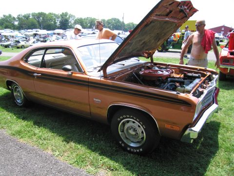 2001 Ford Crown Victoria - Photograph of a brown Plymouth Duster with open hood at a car show, not a technical document.