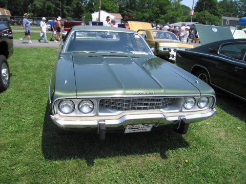 2001 Ford Crown Victoria - Photograph of the front of a green Plymouth sedan, not a technical document.