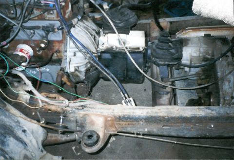 1983 Ford Bronco - Close-up view of the engine bay, showing the transmission, various wires, and mechanical components.