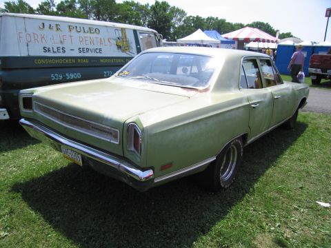2001 Ford Crown Victoria - Photograph of a green Plymouth sedan beside a van, not a technical document.
