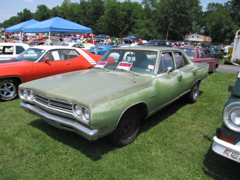 2001 Ford Crown Victoria - Photograph of a green Plymouth sedan at a swap meet, not a technical document.