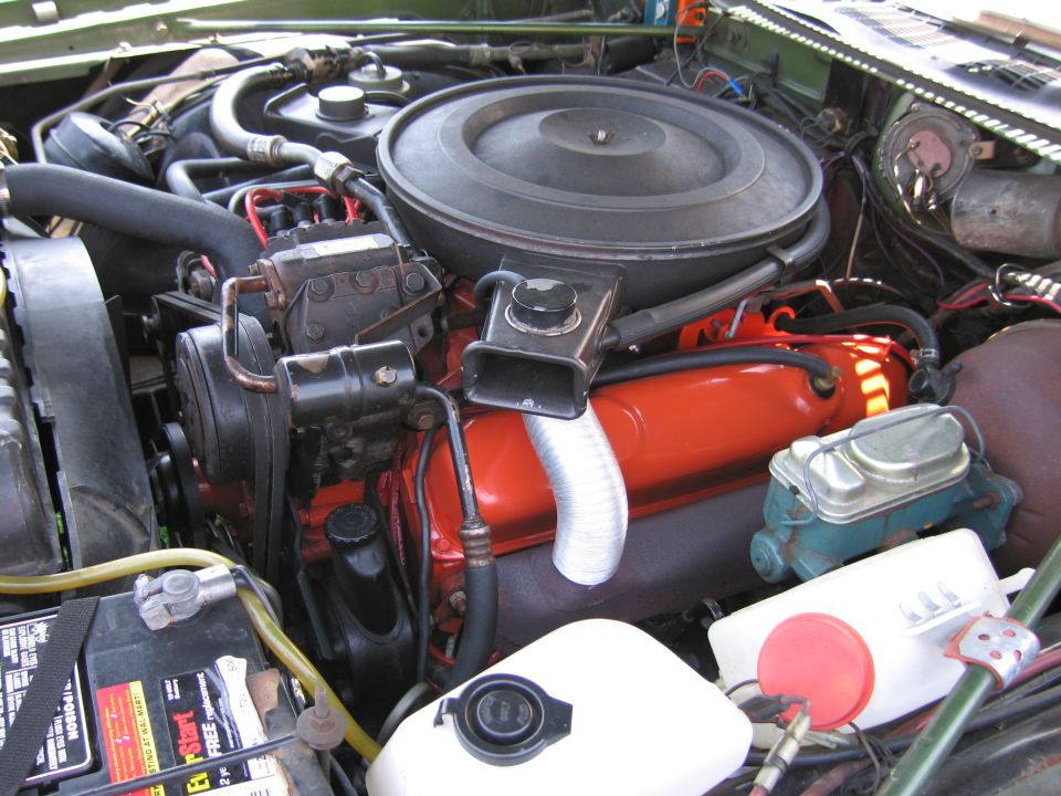 Engine bay with black air cleaner over an orange V8 engine