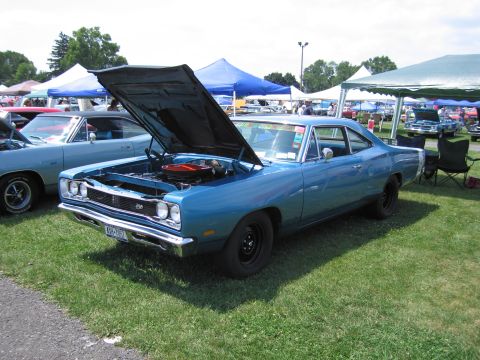 2001 Ford Crown Victoria - A blue 1969 Dodge Super Bee is displayed at an outdoor car show with its hood open.