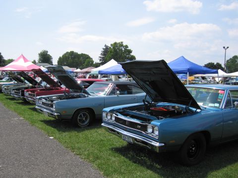 2001 Ford Crown Victoria - Several vintage automobiles are displayed with their engines exposed at a sunny outdoor gathering.