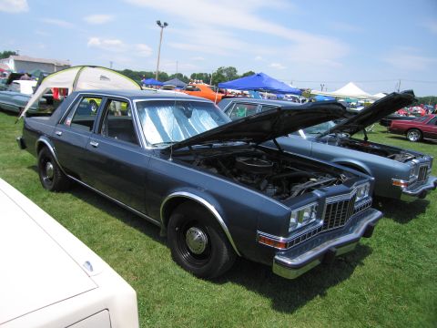 2001 Ford Crown Victoria - Two sedans with hoods open at an outdoor car show on a sunny day.