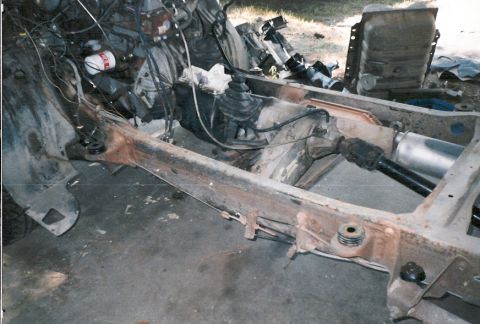 1983 Ford Bronco - The chassis of a vehicle is shown with its engine and drivetrain components exposed, suggesting a restoration or repair process.