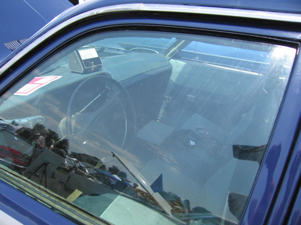 Interior view of blue car with dashboard and steering wheel visible