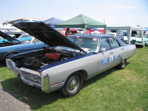 2001 Ford Crown Victoria - A vintage state police car is displayed with its hood open at an outdoor gathering.