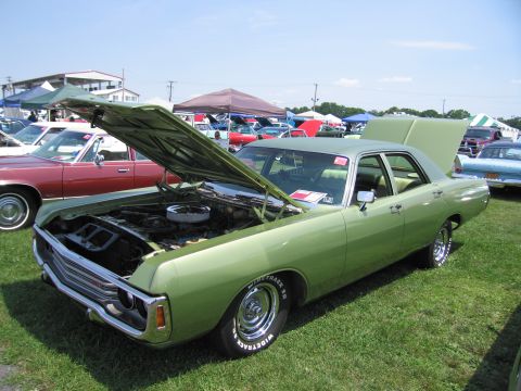 2001 Ford Crown Victoria - Green sedan at a car show, hood and trunk open, with other vehicles in the background.