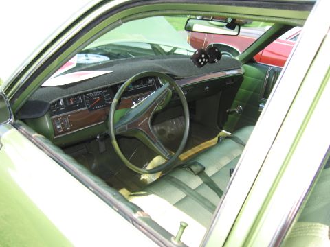 2001 Ford Crown Victoria - The interior of a vintage green car is visible, with a dashboard and seats. Another car is seen through the window.