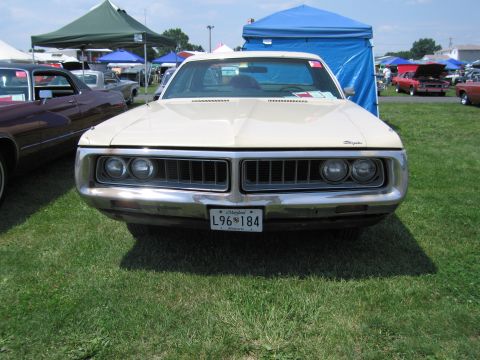 2001 Ford Crown Victoria - A vintage Chrysler sedan is parked on grass at an outdoor event with tents and other cars in the background.