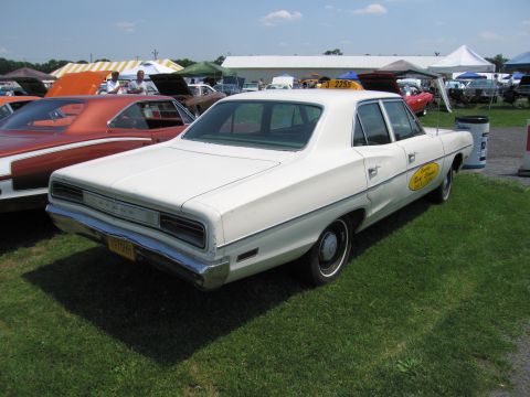 2001 Ford Crown Victoria - A white 1968 Dodge sedan, marked as a taxi, is parked on a grassy field next to other vehicles.