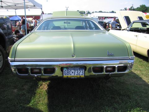 2001 Ford Crown Victoria - A green sedan is parked on grass with other vehicles and tents in the background.