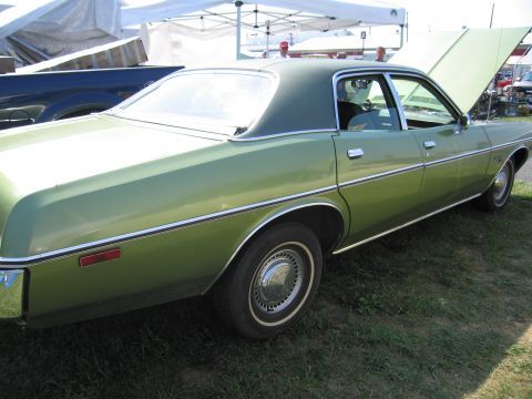2001 Ford Crown Victoria - Side view of a green sedan with its hood open, parked on grass.