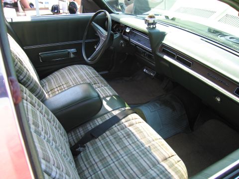 2001 Ford Crown Victoria - The interior features plaid upholstery on the seats and a wood-grain trim on the dashboard.