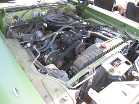 2001 Ford Crown Victoria - The engine bay of a light green vehicle is shown, revealing its internal mechanical components.