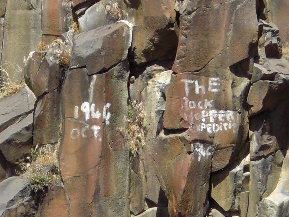 White graffiti on rocks reads '1946 OCT' and 'THE Rock Hopper EXPEDITI 1946'