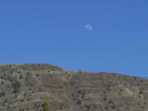 1993 Ford Bronco - The moon hangs in the sky over a , arid landscape.