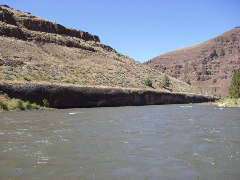 1993 Ford Bronco - A wide river winds through a canyon landscape under a bright blue sky.