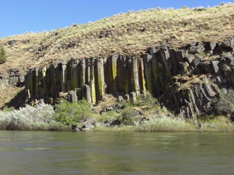 1993 Ford Bronco - Natural basalt columns form a striking geological formation along a riverbank.