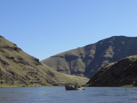 1993 Ford Bronco - A boat navigates a river between two large, arid hills on a sunny day.