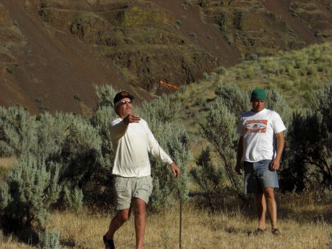1993 Ford Bronco - Two men are outdoors in a dry, brushy landscape with a rocky hill behind them.