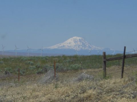 1993 Ford Bronco - A scenic view of a snow-capped mountain with wind turbines in the distance and a rustic fence.