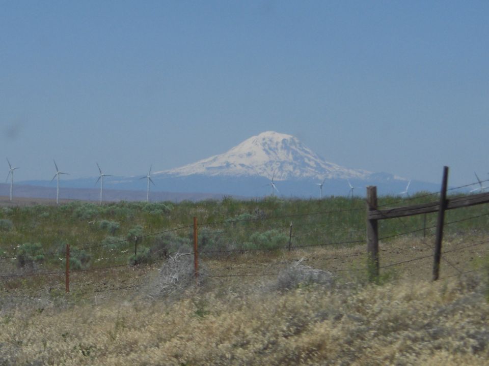 Mountain landscape with wind turbines and a wooden fence in the foreground