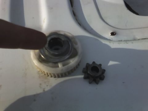 1996 Ford Bronco - Two gears are shown, one plastic and one metal, with a finger indicating the larger component.