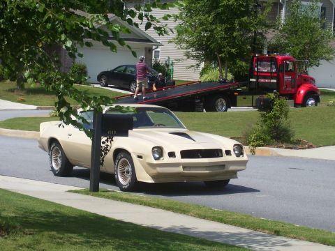 1979 Chevrolet Camaro - A tan 1979 Chevrolet Camaro is parked on a residential street, with a tow truck in the background.