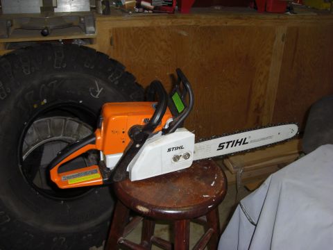 1993 Ford Bronco - A Stihl chainsaw is placed on a stool, with a large tire visible in the background.