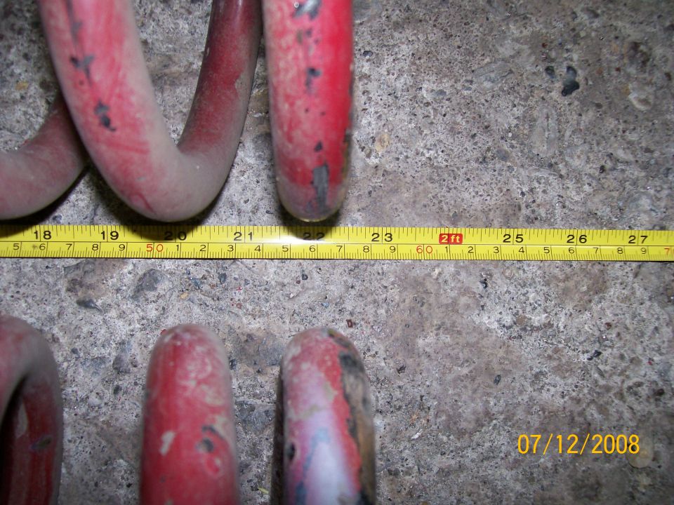 red coil springs being measured with a tape measure