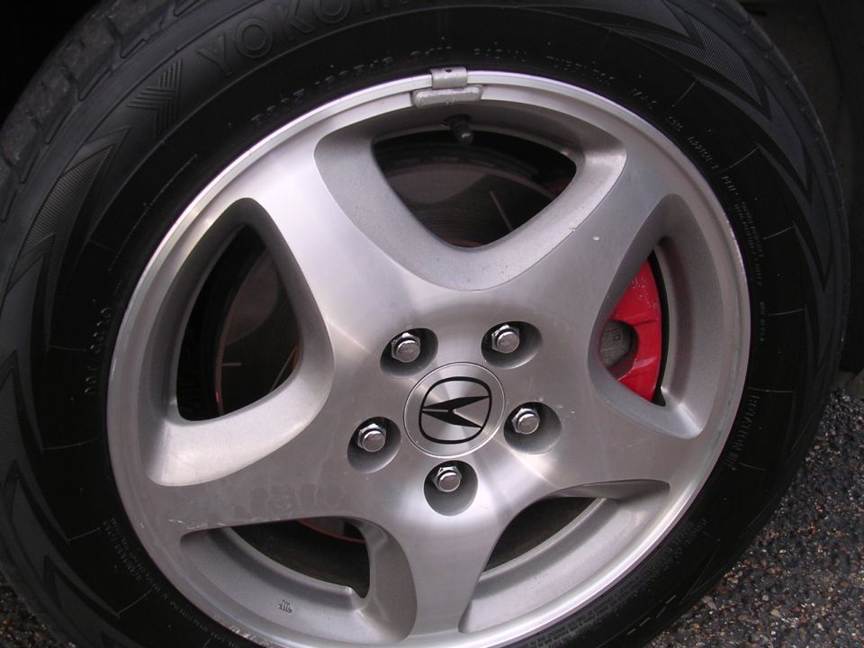 Close-up of a 2003 Acura TL wheel and red brake caliper