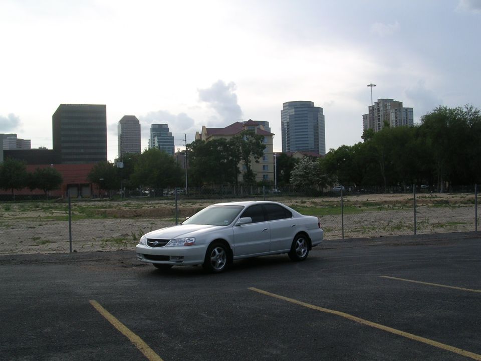 White 2003 Acura TL parked with city skyline behind it