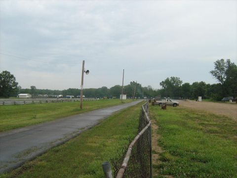 1988 Mercury Grand Marquis - A drag strip scene with a pickup truck parked near the track on a cloudy day.