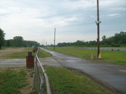 1988 Mercury Grand Marquis - A view down a drag strip on a cloudy day, with wet pavement and grassy areas.